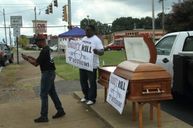 A supporter takes a photo of the casket.
